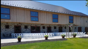 Philadelphia wedding outdoor wedding ceremony with elegant chairs, wedding flowers, waterfront views and green landscaping